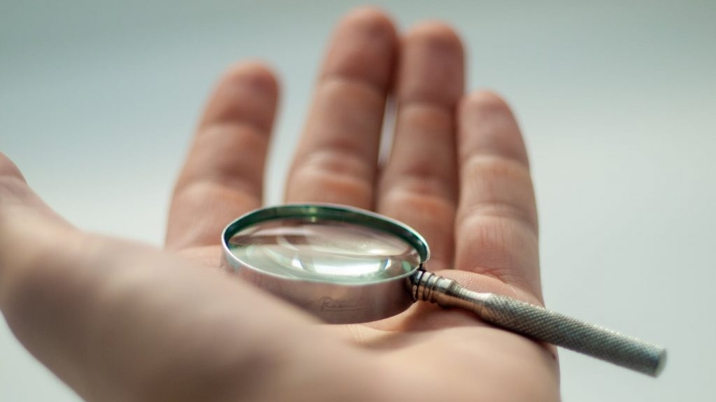 Main tenant une loupe